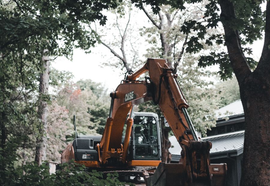 Excavator working beside a Hamilton County house in a stand of trees